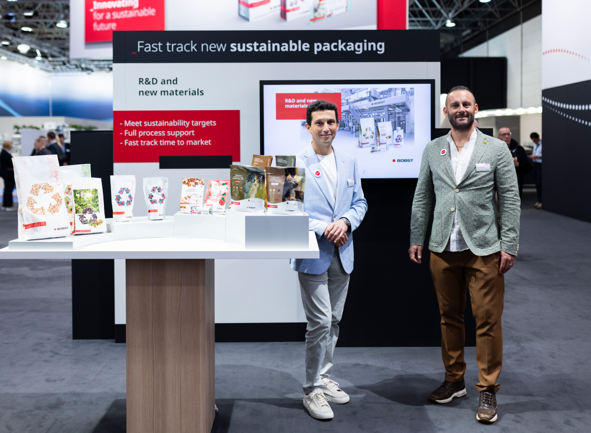 BOBST expert engaged in a stand conversation with a visitor at Drupa 2024